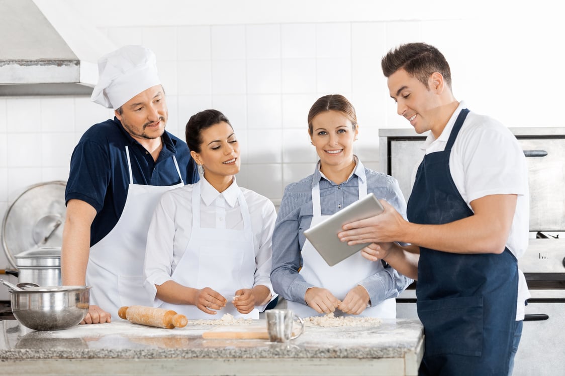 Chefs Checking Recipe on Tablet Computer in Kitchen